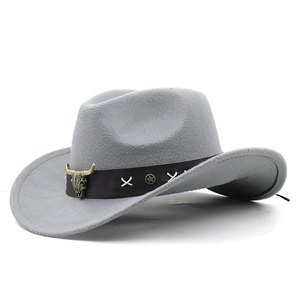 Detail of light gray cowboy hat featuring a leather band with a metal bull skull ornament