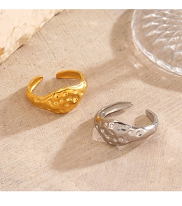 Detail of 18K gold and silver plated hammered texture stainless steel rings on stone