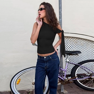 Gros plan d'un haut noir asymétrique à bretelles porté avec un jean en style urbain