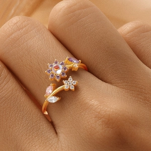 Detail of floral S925 silver ring with purple and pink crystals on a model's hand