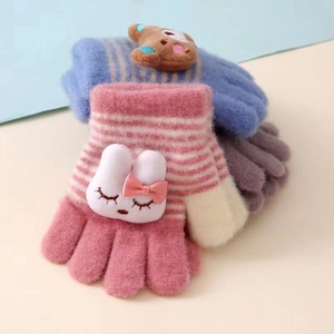 Gros plan de gants tricotés pour bambins avec mignons écussons lapin et ours