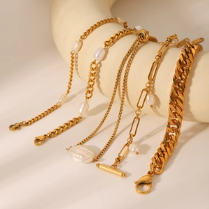 Close-up of golden stainless steel chains and freshwater pearl bracelets on a display