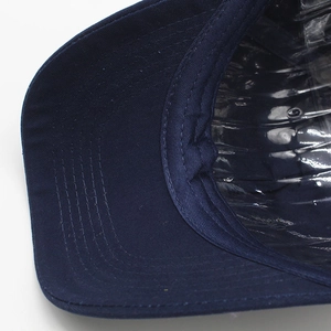 Detailed close-up of navy blue cotton baseball cap brim with five-row precision stitching