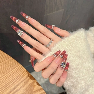 Red-brown cat eye press-on nails with rhinestones and coffin shape on hands