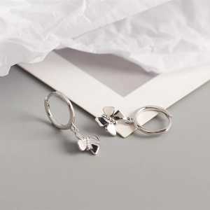 Detailed macro view of S925 sterling silver butterfly hoop earrings on neutral background