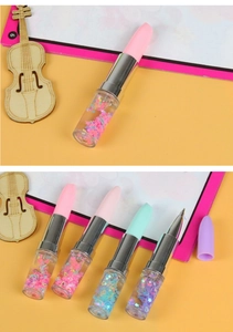 Macro detail of lipstick-shaped pens with colorful liquid glitter and fine ballpoint tip