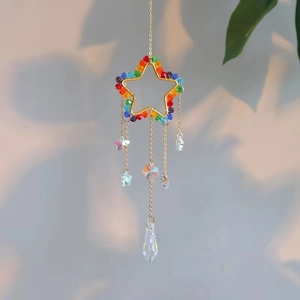 Detail of star-shaped crystal suncatcher with rainbow beads and golden metal frame