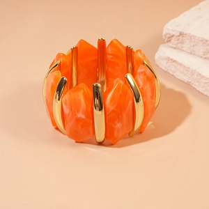 Gros plan détaillé du bracelet en acrylique orange avec des séparateurs en métal doré