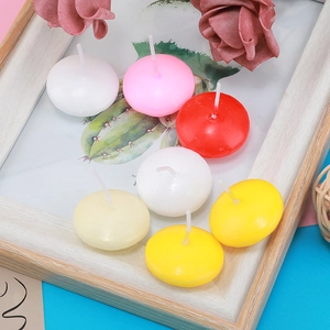 Close-up of colorful spherical floating candles with decorative dried flowers on wood