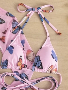 Detailed flat lay of pink butterfly print bikini set with matching sarong wrap cover-up