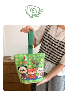Detail of green checkerboard canvas bucket bag with wooden ring handle and cartoon print