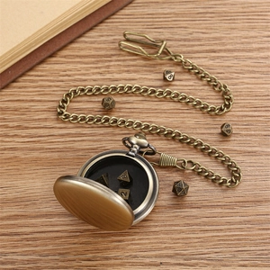 Detail of bronze pocket watch with hollow gear cover and metal DND dice set inside