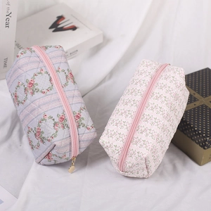 Floral quilted cosmetic bags in pink and grey colors with secure gold zipper closures