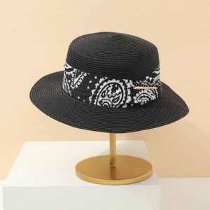Detail of black straw fedora with paisley band and gold fashion show metal plaque