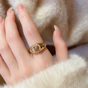Close-up of gold plated ring with brown tiger eye stone and zircon accents on model