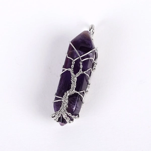 Detail of silver wire wrapped tree of life design on natural hexagonal amethyst pendant