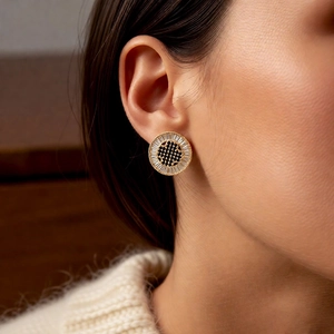 Close-up of 18k gold plated round stud earring with black and clear cubic zirconia stones