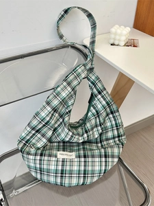Sac hobo rétro en toile à carreaux vert et noir avec large bandoulière dans un décor