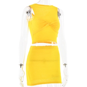 Dettaglio di un set a due pezzi in maglia gialla con crop top a incrocio e minigonna