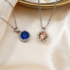 Macro view of sunflower-shaped pendants with sapphire blue and champagne zircon stones