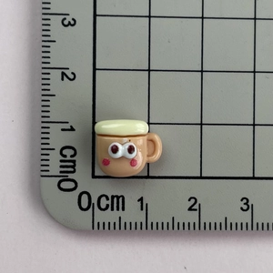Macro shot of 1.2x1.5cm resin coffee cup charm with cute face and measuring ruler