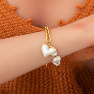 Bracelet en acier inoxydable doré avec pendentif cœur en nacre et détails en perles