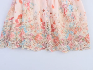 Détail de l'ourlet de robe fleurie rose avec dentelle délicate et boutons en perles