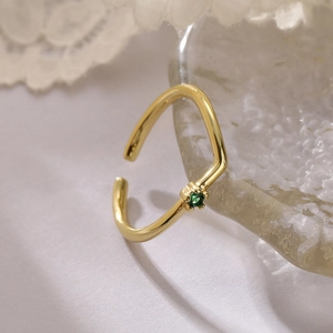 Detail of 18K gold plated open ring featuring a sparkling green zircon gemstone