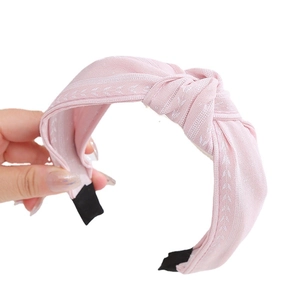 Serre-tête en tissu rayé rose avec nœud croisé large pour un style minimaliste