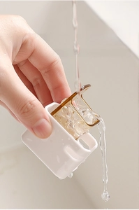 Close-up of detachable toothbrush holder being washed under running water for hygiene