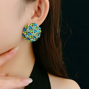 Detail of vintage geometric earrings with blue and green crystals on a model
