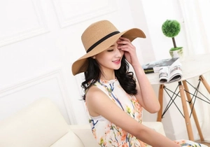 Macro detail of natural woven straw hat with classic black ribbon bow for summer