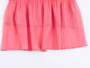 Detail of bohemian pleated pink skirt hem featuring high-quality chiffon fabric texture