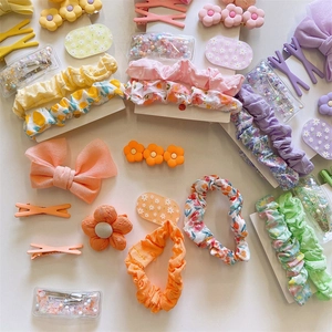 Detail view of assorted floral fabric scrunchies and colorful floral hair clips for girls