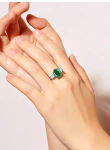 Close-up of luxury S925 silver ring featuring oval emerald gemstone and side stones