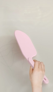 Pink bed sheet tucker tool with ergonomic handle for smoothing linens and cleaning hair