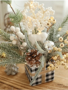 Christmas centerpiece with pine branches, white deer, LED lights, and buffalo check base