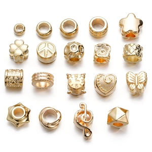 Detailed macro shot of diverse golden CCB spacer beads with star and heart shapes