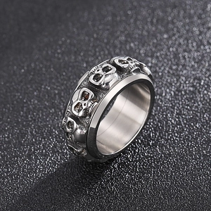 Detailed close-up of retro silver skull ring showing intricate embossed punk patterns