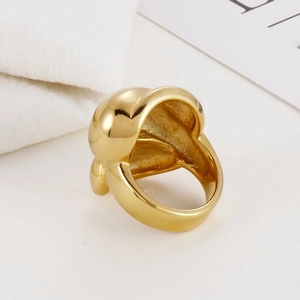 Detailed view of gold fishnet mesh stainless steel ring on elegant knit background