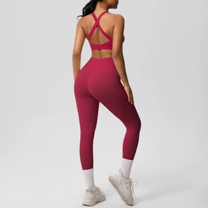 Detail of cross-back yoga bra and high-waist leggings set in deep red premium fabric