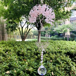 Close-up of pink crystal tree of life with butterfly charm and hanging prism ball