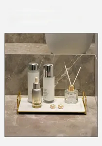Detail of a rectangular marble storage tray with gold metal frame and side handles