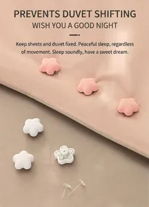 Detail of star-shaped duvet clips in pink and white fabric with secure fixing pins