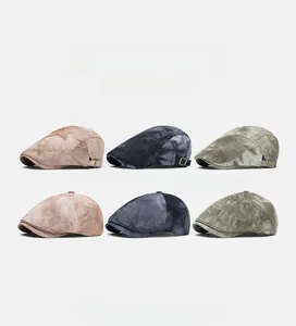 Detail view of washed cotton newsboy hats in khaki, blue and green with metal buckles