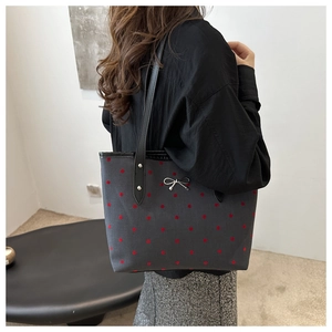 Detailaufnahme einer dunkelgrauen Polka-Dot-Einkaufstasche mit silberner Schleife
