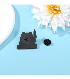 Detail view of the black cat with knife enamel pin showing the back and butterfly clutch