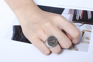 Macro detail of large round druzy ring featuring colorful crystals on silver polished band