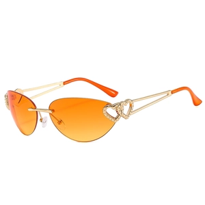 Frameless Y2K sunglasses with orange gradient lenses and gold heart-cutout temples