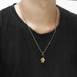 Detail of a 3D gold astronaut pendant on a sleek snake chain against a black background
